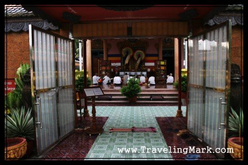 Buddhists Praying at the Wat Preah Prom Rath Temple Seen Through the Gate