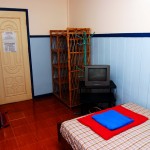 Entrance to the Room with View of Clothes Rack and a TV Set