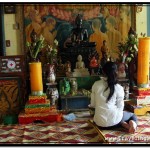 Photo: Girl Praying Before Buddha Statue at Wat Damnak Vihara