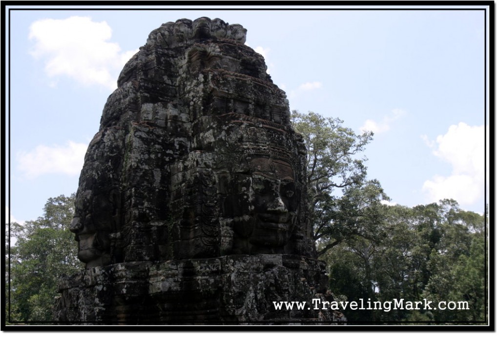 Photo: Bayon Face Tower Towering Before Tall Cambodian Trees