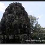 Photo: Bayon Face Tower Towering Before Tall Cambodian Trees