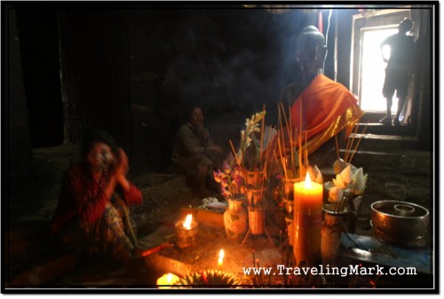 Photo: Cambodian Woman Praying Before the Statue of Buddha at Bayon Temple