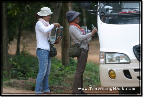 Photo: Touts at Angkor Wat Selling Bootleg Books to Tourists on a Tour Bus